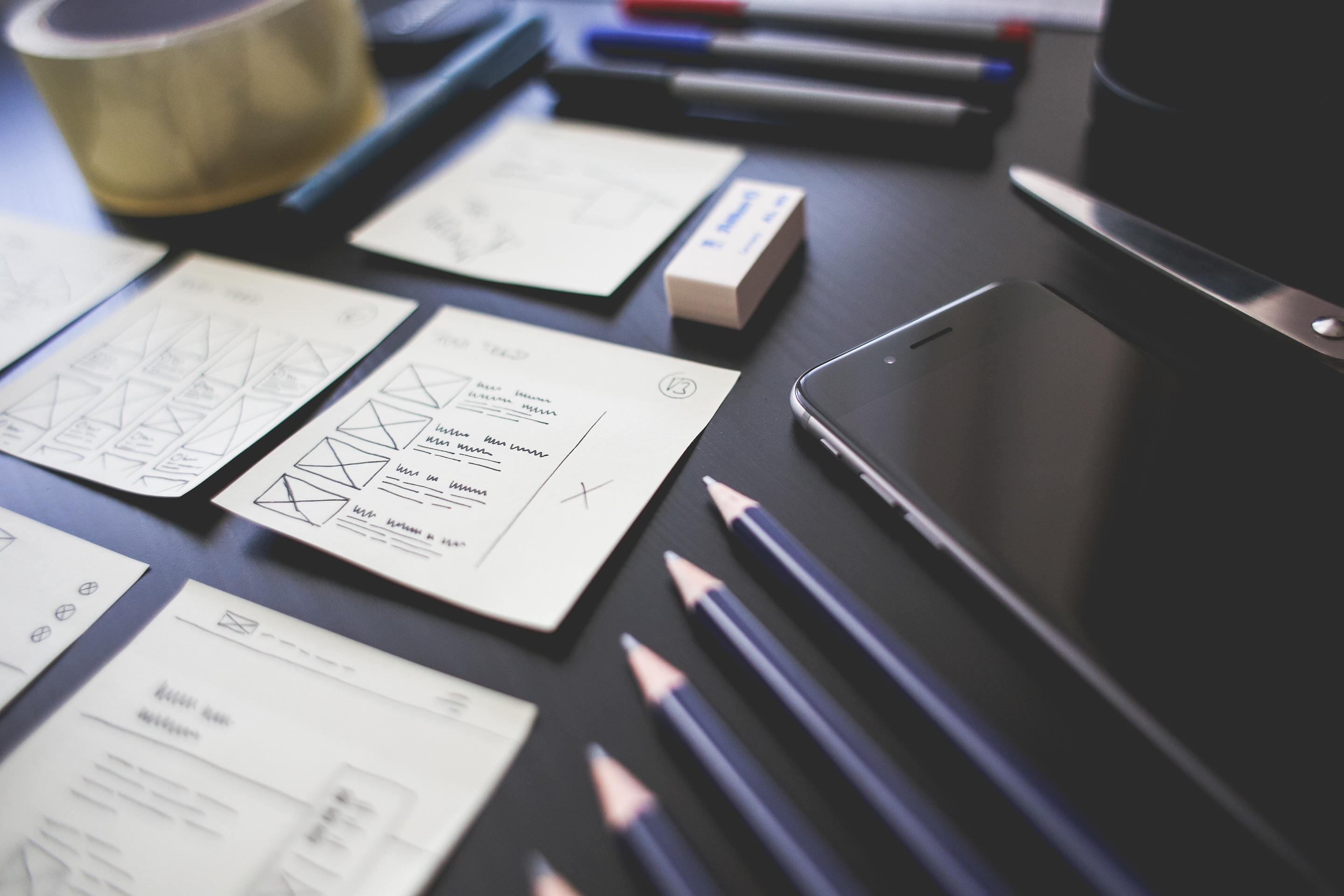 A phone and pencils on a desk.