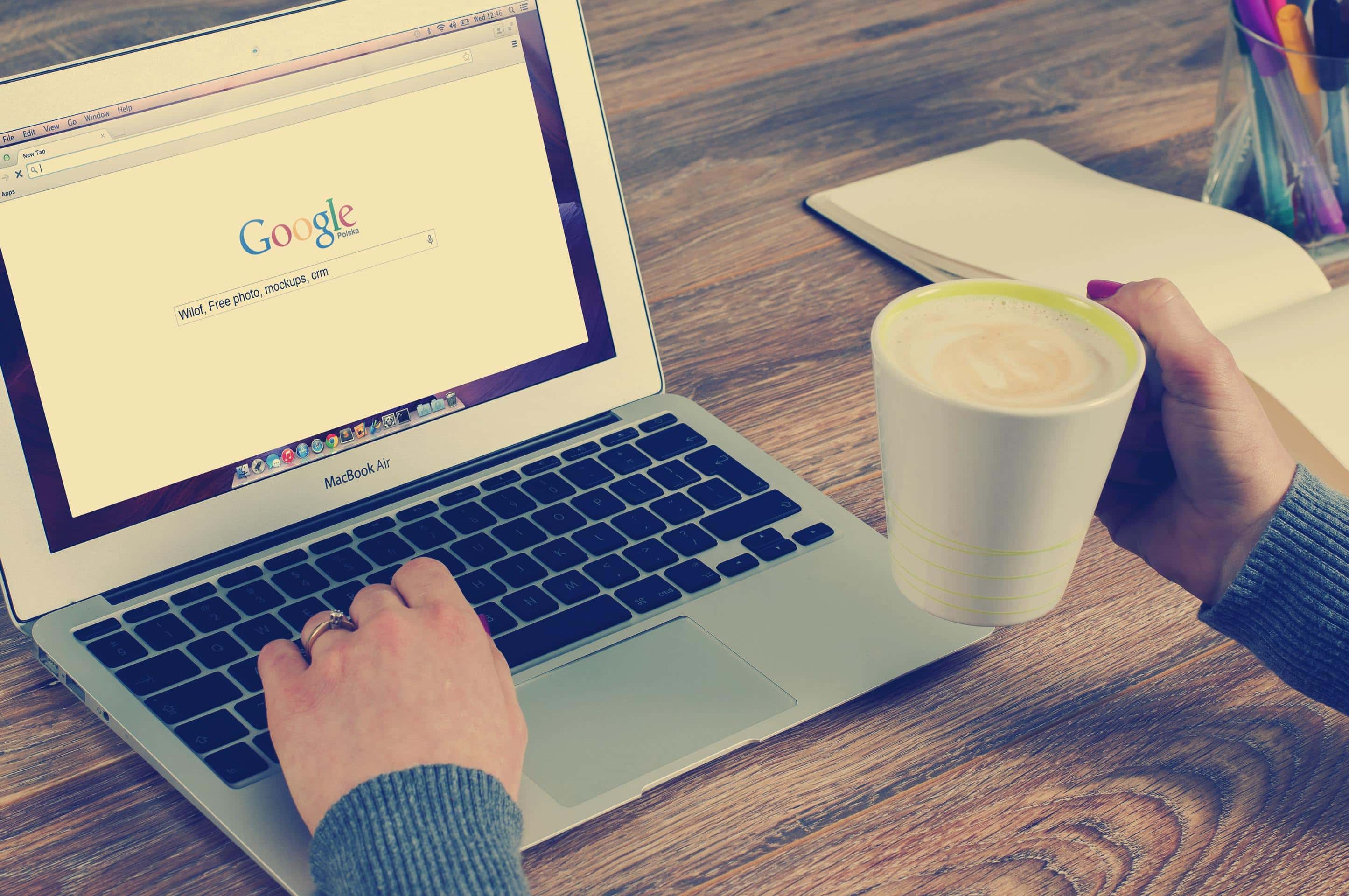 A person conducting Search Engine Optimization (SEO) on a laptop using google search.