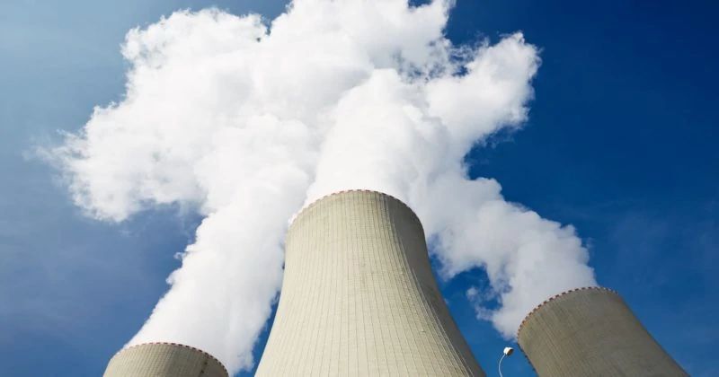 Two manufacturing companies with cooling towers emitting smoke.