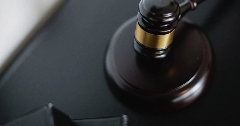A judge's gavel sits on a desk.