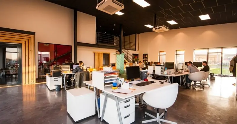 A large open office with people working at desks selling WordPress businesses.