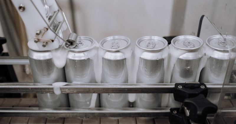 A machine is automatically depositing aluminum cans into a sophisticated apparatus.