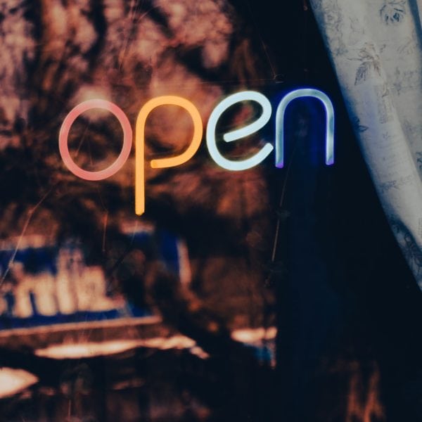 A neon sign advertising local SEO services with the word open displayed prominently.