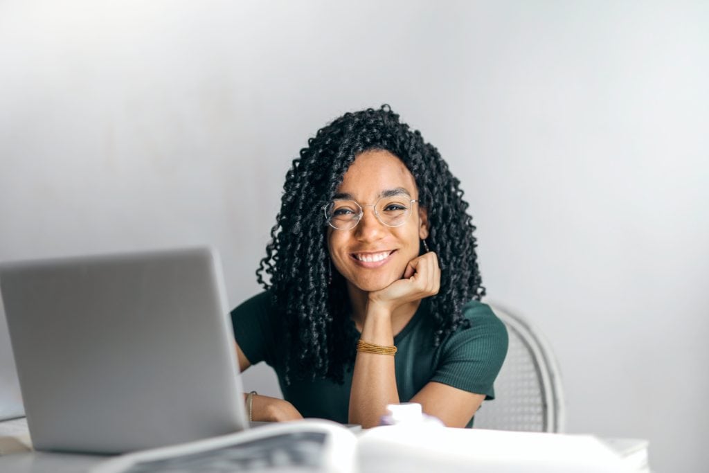 A young African American woman with dreadlocks working at a nonprofit organization.