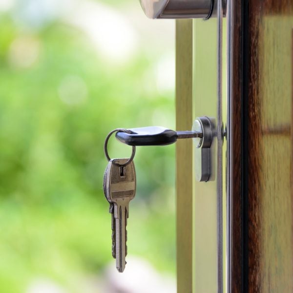 A key is attached to a real estate door.