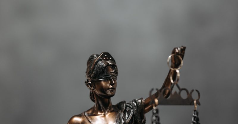 A woman holding scales of justice on one of the 22 Best Law Firm Websites.