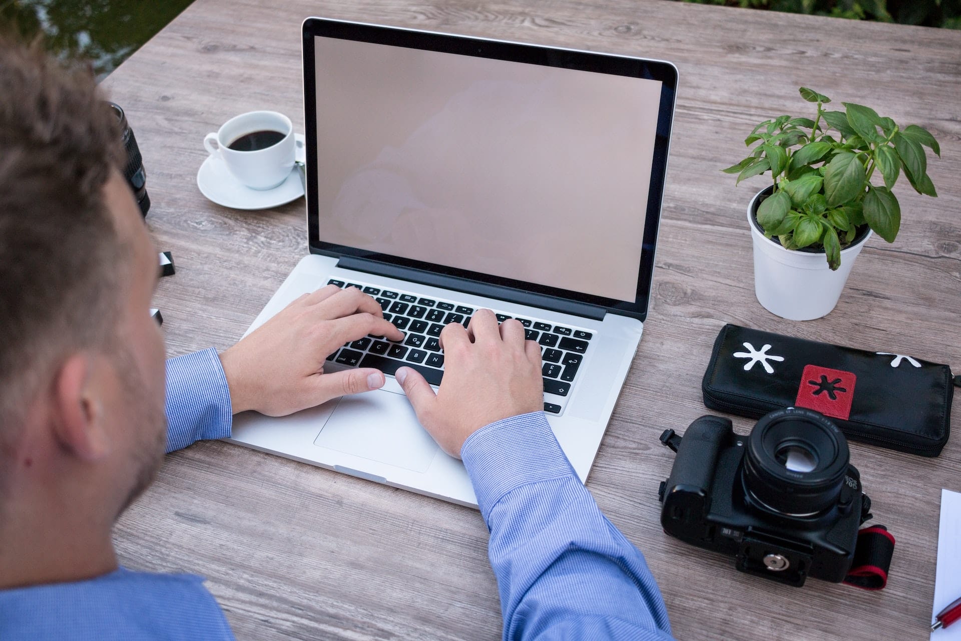 A man using a laptop on a wooden table for SaaS.