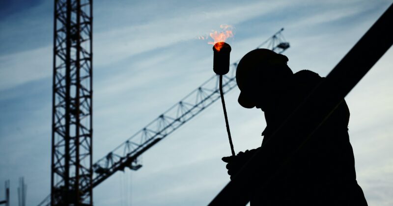 A construction worker holding a torch featured on one of the 22 best construction websites.