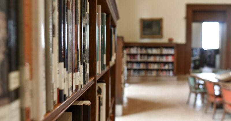 A row of bookshelves in a library filled with educational resources.