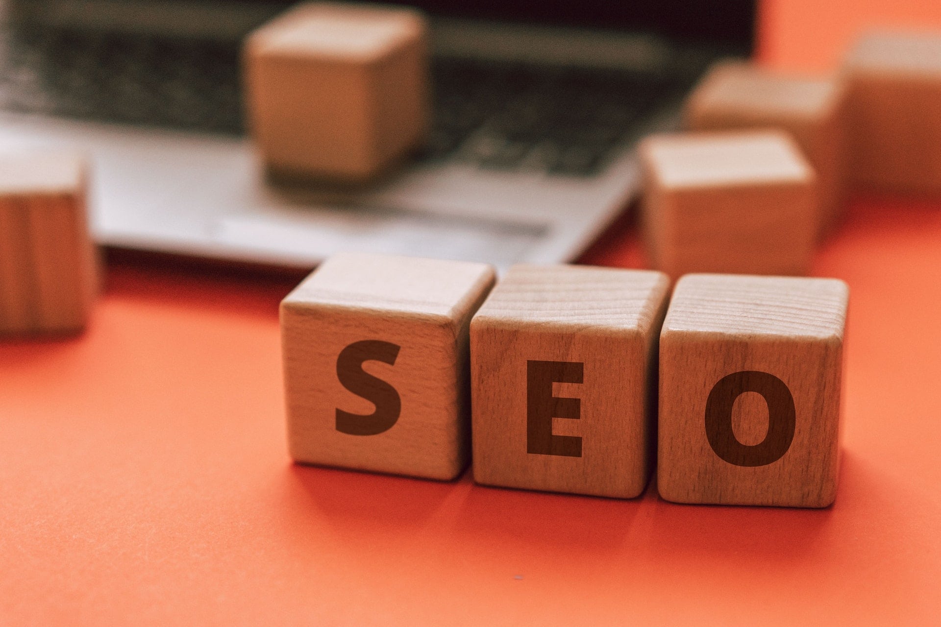 Wooden blocks spelling out "seo" next to a laptop, illustrating blog post introduction tips.