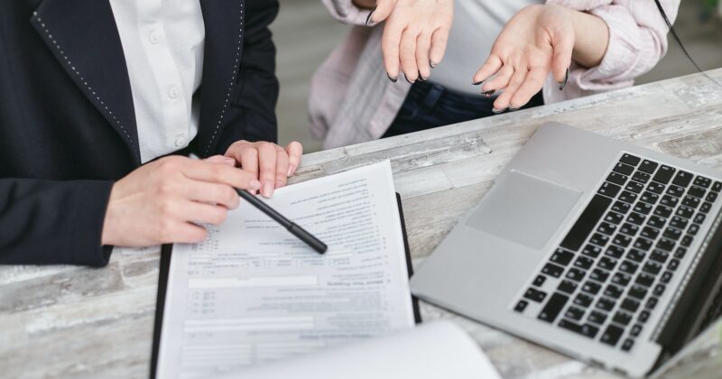 Two business people working on paperwork at a desk in the setting of one of the 22 best insurance websites.