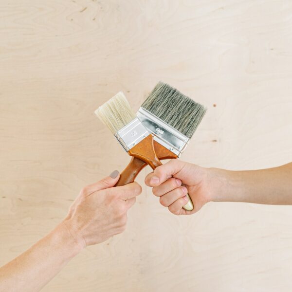 Two hands on wooden background.