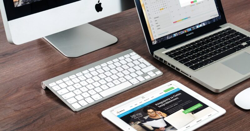 A versatile setup featuring a laptop, tablet, mouse, and keyboard arranged neatly on a desk.