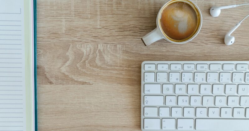 A website content thought starter featuring a notebook and keyboard on a wooden desk.