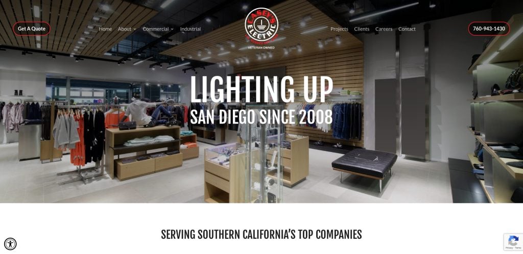 Modern clothing store interior with shelves and racks of apparel, displayed on a website for a San Diego-based lighting company. Like the best electrician websites, top navigation highlights services, and contact info is visible. Text: “Lighting Up San Diego Since 2008.”.