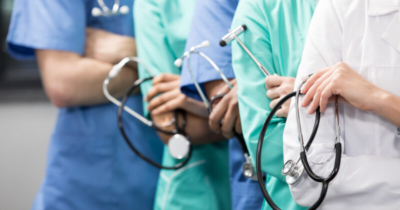 A group of doctors holding stethoscopes and working on the 20 best healthcare websites.