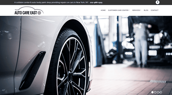 Close-up of a car wheel in an auto repair shop, with another vehicle and a mechanic in the blurred background. Perfect for showcasing auto repair websites, the header displays the shop name and navigation menu.