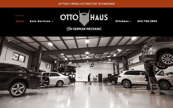 Interior view of a top auto repair shop with several cars lifted on hydraulic lifts, mechanics at work, and the Ottohaus logo and contact information displayed at the top—a great example for auto repair websites.