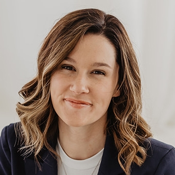 Lindsey, a woman in a blazer, smiles for the camera.