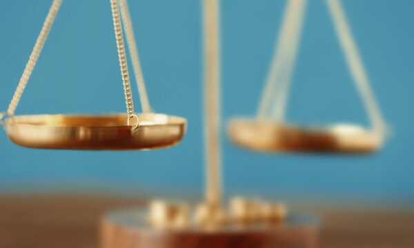 A gold balance scale on a wooden table, providing an effective valuation.
