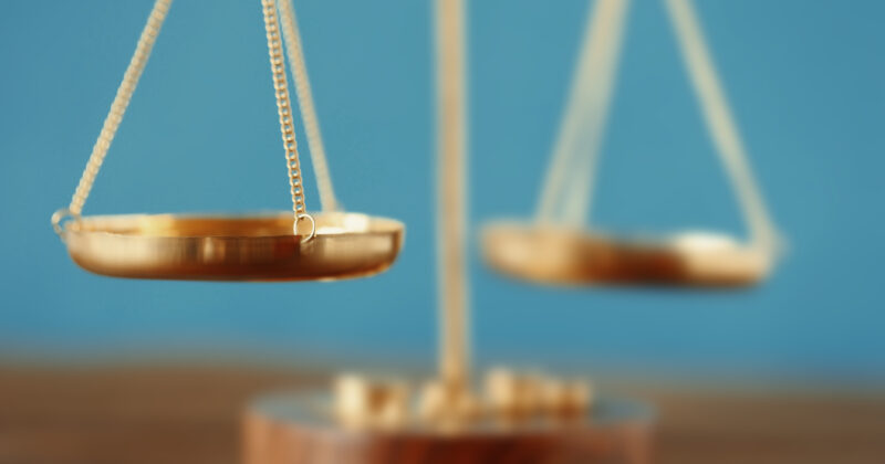 A gold balance scale on a wooden table, providing an effective valuation.