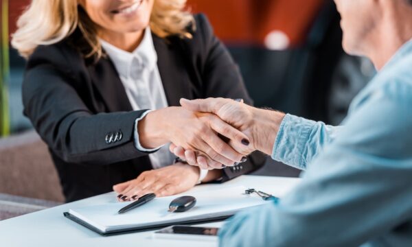 A buyer and seller shaking hands at a table.