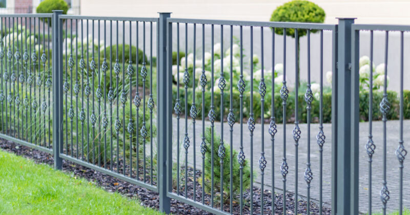 A metal fence adorning the exterior of a house, perfect for fence company websites.