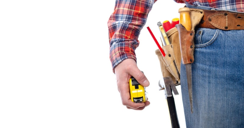 A handyman proudly displaying his tool belt on a websites.