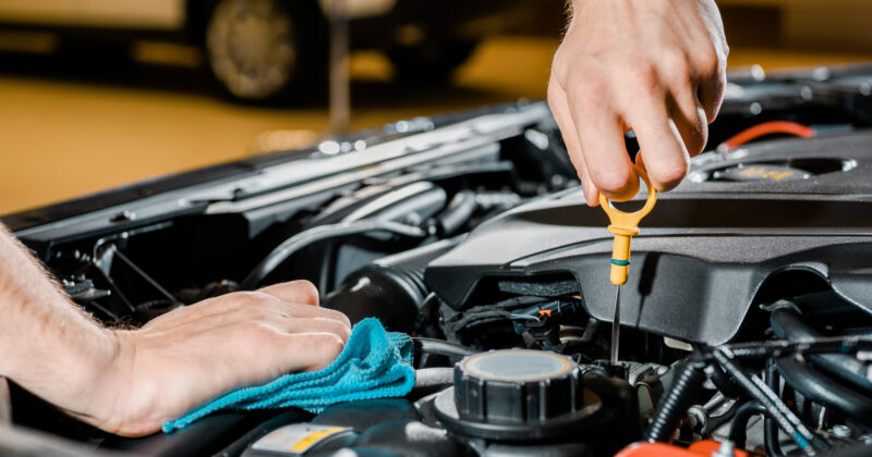 Best Auto Mechanic checking oil level in a car engine.