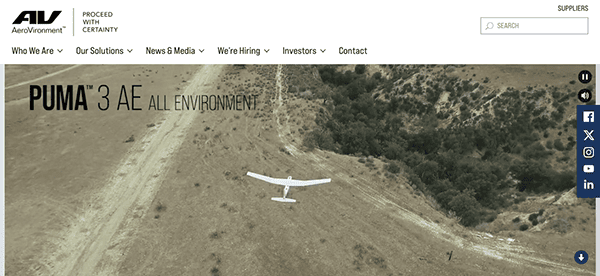 Unmanned aerial vehicle (uav) named puma 3 ae by aerovironment, positioned for launch on a dirt pathway within a hilly landscape.