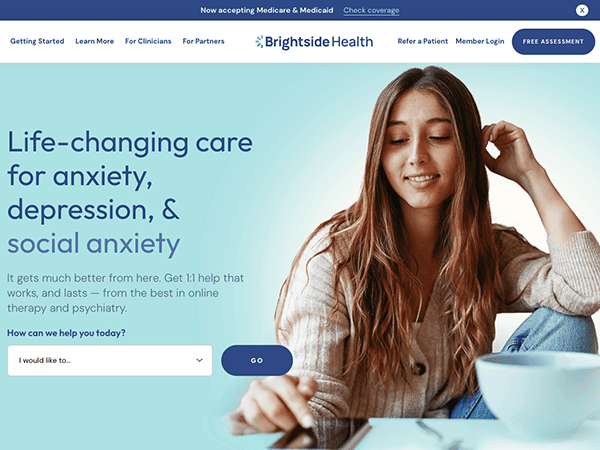 Woman smiling while looking at laptop next to a cup of tea with text about online mental health services.