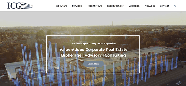 Corporate website homepage featuring real estate services against an aerial backdrop of urban development.