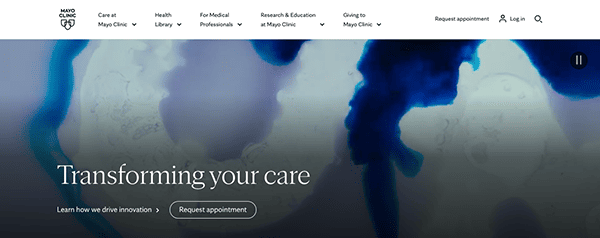Website homepage of mayo clinic featuring a blue-toned background with abstract designs, highlighting their commitment to transforming healthcare with options to learn more and request an appointment.