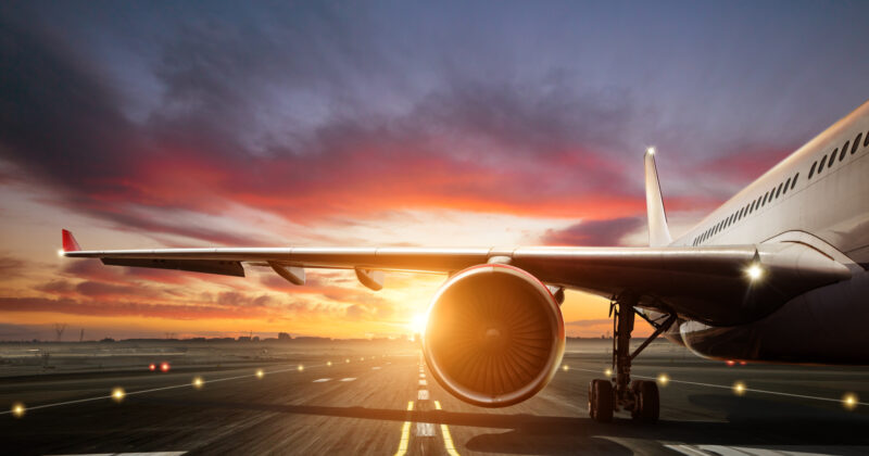 Commercial airplane on the runway during sunrise, showcasing best aerospace website design inspiration.