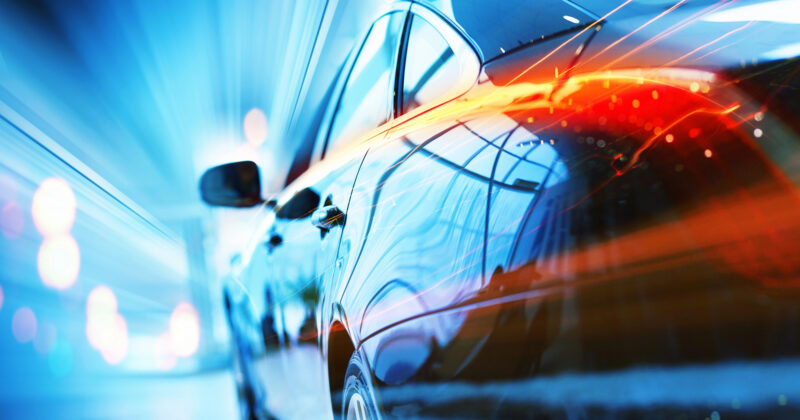 A dynamic automotive design image of a car in motion at night, with light streaks indicating speed.