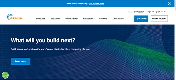 Website homepage of akamai featuring a header with navigation links, a large banner asking "what will you build next?" and a green digital wave graphic background.
