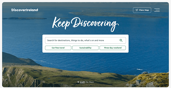 Screenshot of the "discover ireland" website homepage featuring a scenic view of coastal cliffs with a search bar offering travel options.