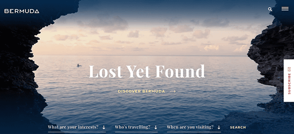 Website banner featuring a serene view of the ocean seen between two cliffs, with a distant boat and a promotional tagline for bermuda tourism.