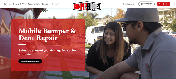 A man and a woman sitting outside reviewing a document beside a red car, with a red overlay displaying text about mobile bumper and dent repair services.