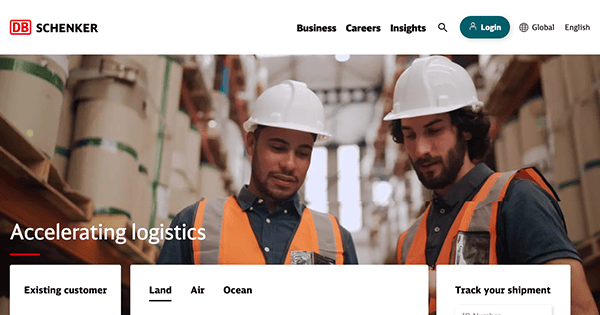 Two workers in safety gear with helmets and reflective vests inside an industrial facility, examining documents, with the text "Accelerating logistics" displayed.