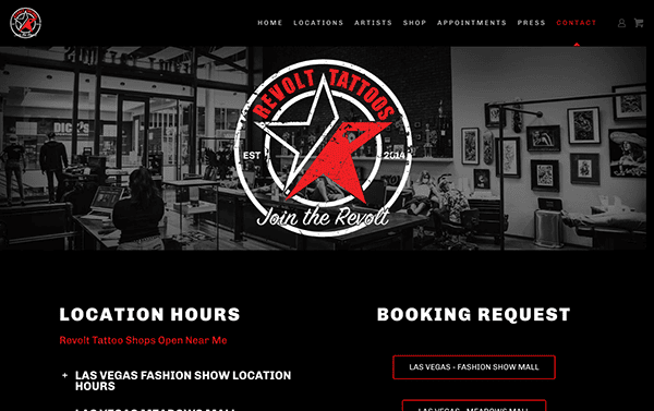 Interior of revolt tattoos shop with customers and tattoo artists visible; prominent red and black branding, including logo, in a modern setting.
