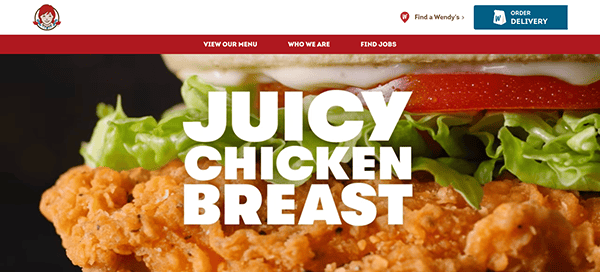 A close-up image of a wendy's chicken sandwich featuring crispy chicken breast, lettuce, and mayonnaise on a bun, with the text "juicy chicken breast" overlaying the image.