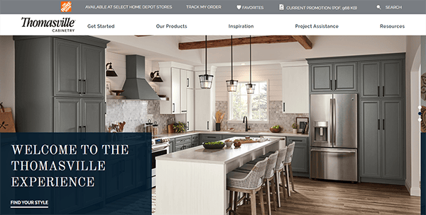 A modern kitchen with gray and white cabinets, a large island with seating, stainless steel appliances, and wood beam ceiling, featured on the Thomasville Cabinetry website.