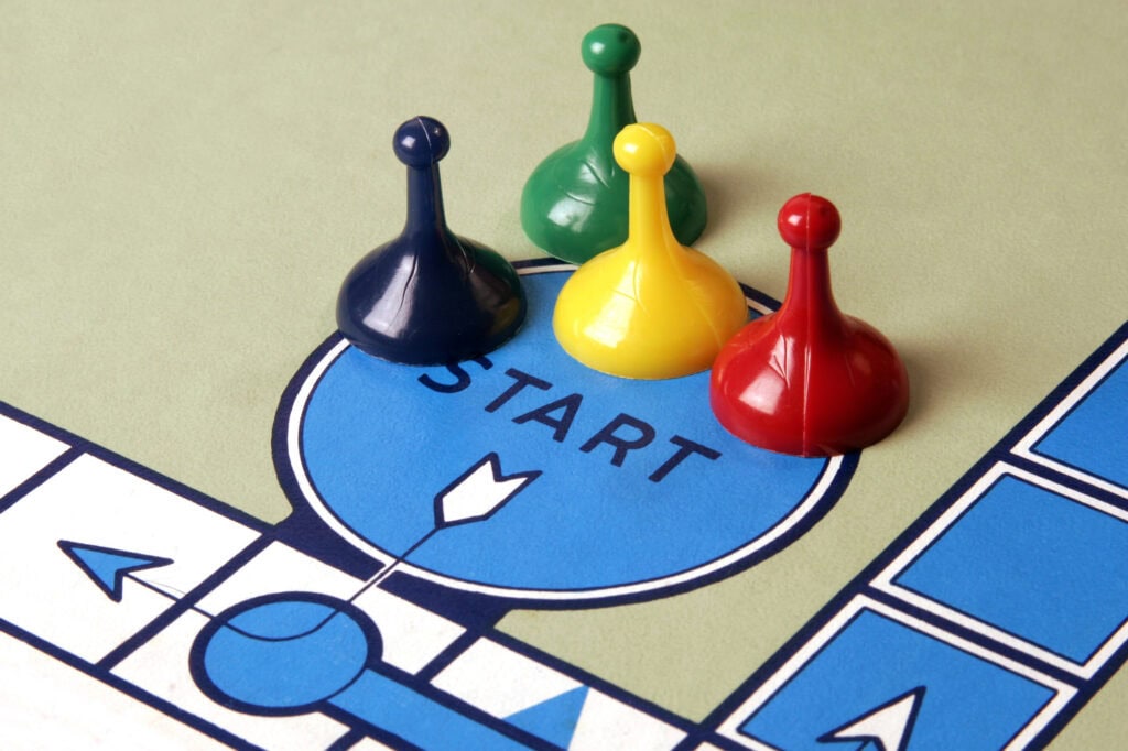 Four game pieces in blue, green, yellow, and red are positioned on a "START" space on a board game, ready to lead you on an exciting adventure. With rules as detailed as effective privacy policies and gameplay as strategic as mastering SEO, every move matters.