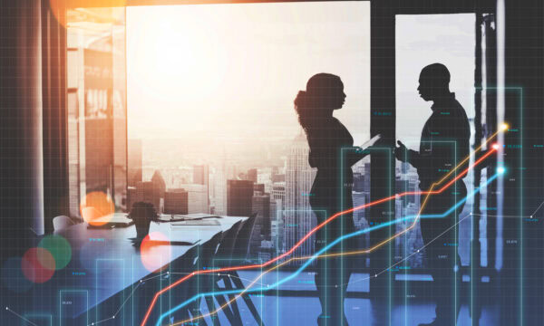 Two people converse in a modern conference room with a city view at sunset. A digital overlay of rising graphs suggests how optimizing their Google Business Profile could drive financial growth.