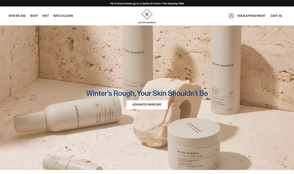 Skincare products are elegantly displayed on a beige surface, surrounded by stones. The text in the center reads, "Winter's Rough, Your Skin Shouldn't Be—Keep It Smooth Like the Best Barber Shop Experience.