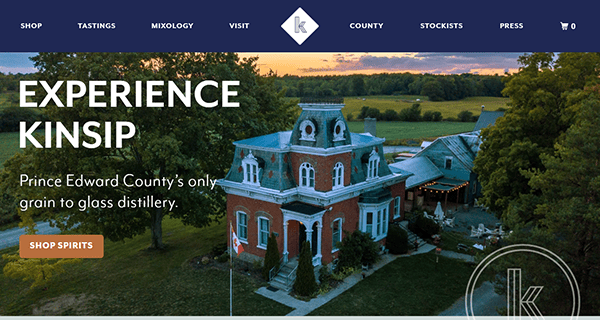 Aerial view of a distillery with a historic building surrounded by trees and fields. Text reads: "Experience Kinsip, Prince Edward County's only grain-to-glass distillery and explore more through select beverage distributor websites.
