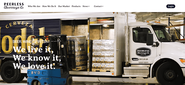 A warehouse scene with a truck from "Peerless Beverage Co" packed with Modelo beer boxes. On the wall, a slogan proudly declares, "We live it, We know it, We love it." Check out their journey on top beverage distributor websites.