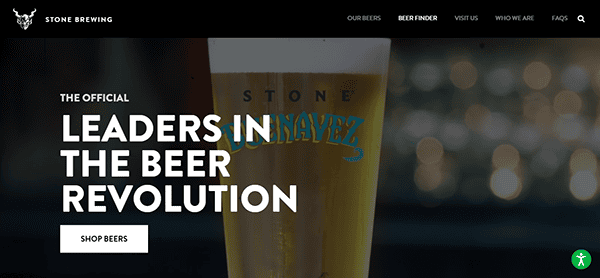 A close-up of a beer glass with the text "LEADERS IN THE BEER REVOLUTION" beside it on a dark background. The site, known for its best brewery websites design, features navigation links and a "Shop Beers" button.