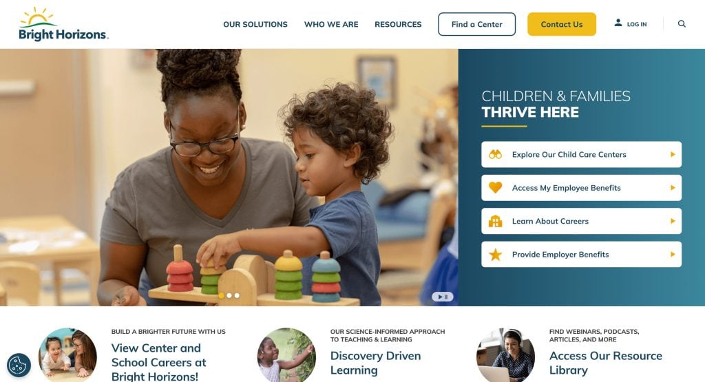 A smiling woman and a young child play with a colorful stacking toy at a table in a bright, welcoming classroom. Buttons to explore the best daycare websites and helpful resources appear on the right.